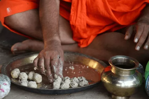 அரிசி, நெய், எள்ளுடன் பிண்டங்கள் தயாரிக்கும் ஒருவர்