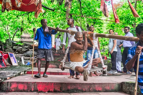 Image of a very old aged man using teh palki to come down from the Pretshila Hill, Gaya, Bihar