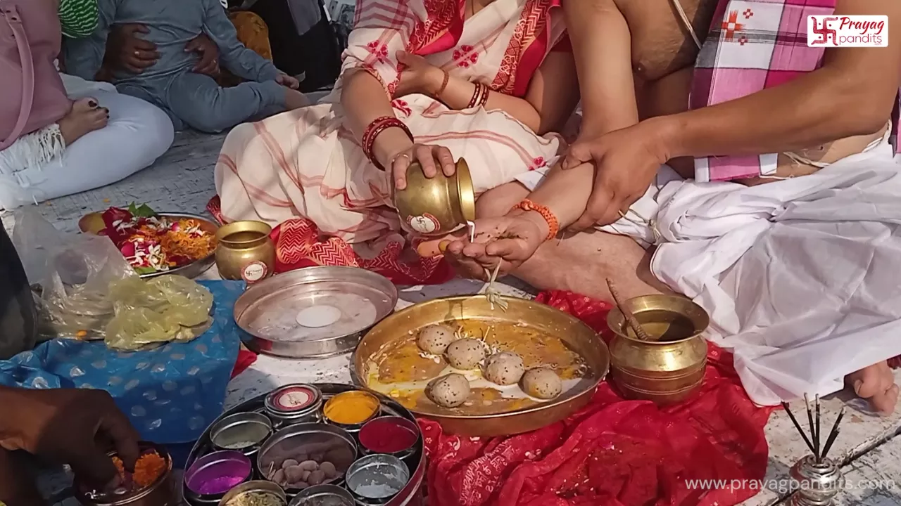A couple performing shradh from a boat at the Triveni Sangam in Prayagraj