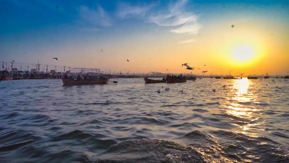 Sunset over the Triveni Sangam with boats moored at the ghat